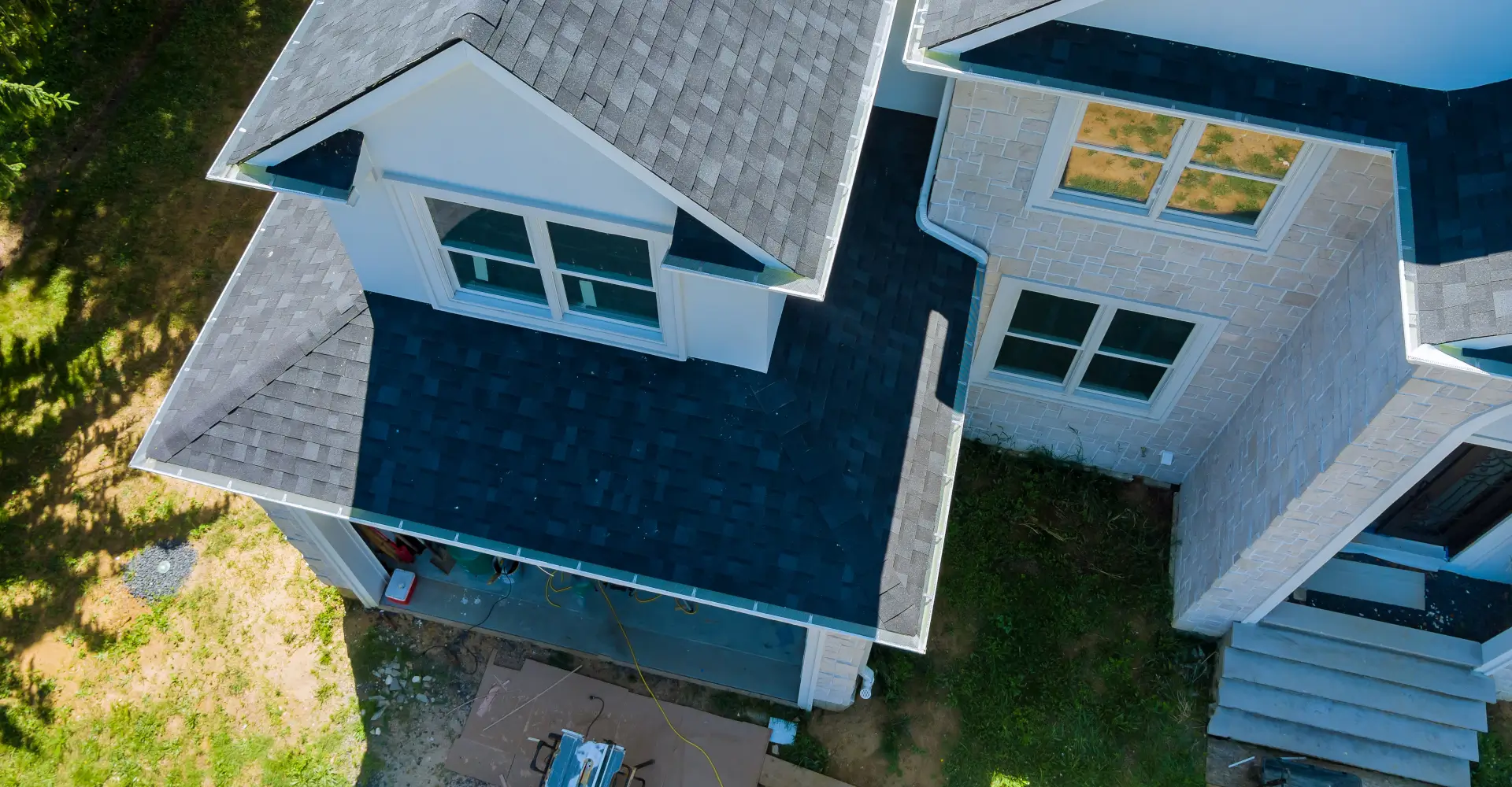 roofing-gutters Rooftop in a new home constructed showing asphalt shingles multiple roof lines with aerial view